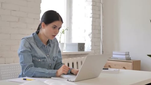 Woman Working at Laptop is Concerned at Home