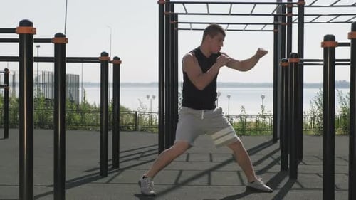 Man Practicing Boxing Outdoors on Sunny Day