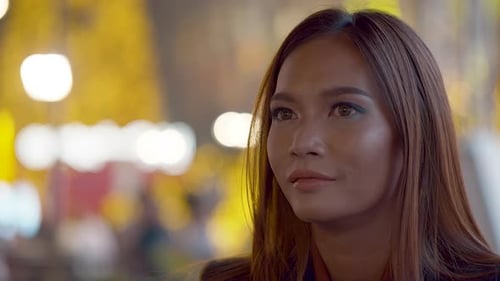 Attraktive junge Frau in der Stadt bei Nacht lächelt in die Kamera - Filmmusik Hintergrund-Bokeh-Licht