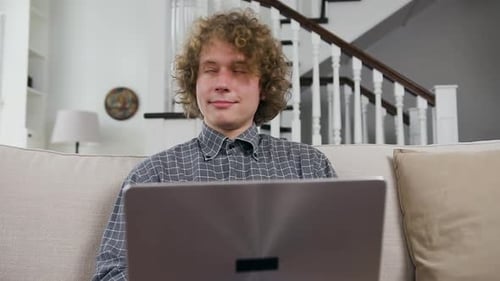 Young Adult Works on Laptop at Home