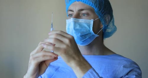 Man in Mask Holding Syringe in Hospital Setting