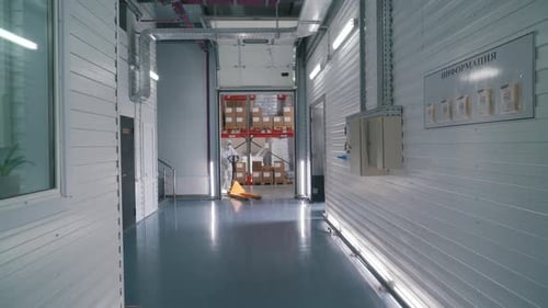 Worker Uses a Stacker To Transport Goods in a Warehouse