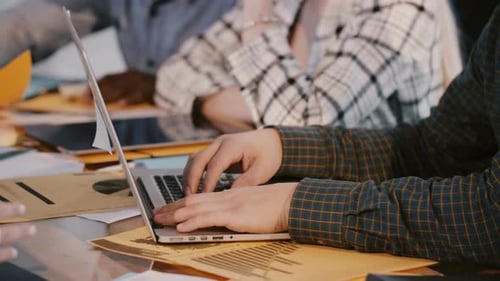 Foto em close-up de mãos de desenvolvedores de software masculinos trabalhando atrás de uma mesa de escritório com laptop no Hackathon