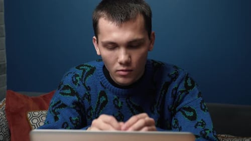 A Focused Tired Sed Young Man Has Bed News Working and Using His Laptop at Home or Office.