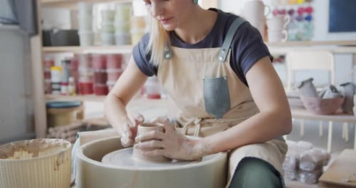 Une potière fabrique un pot sur la roue à poterie