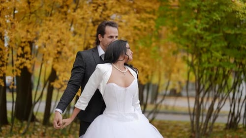 Happy Wedding Couple in Autumn Park Embrace