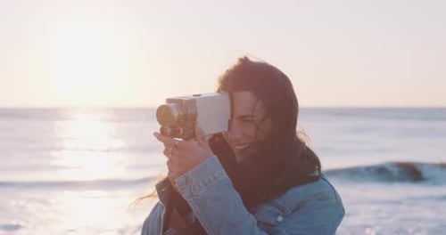 Woman using a camera on a sunny day at the beach