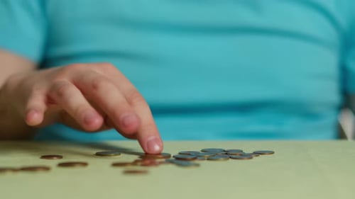 Hands Count Coins on a Table