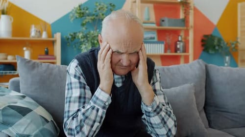 Senior Man Massaging Temples with Headache
