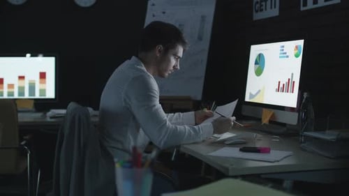 Professioneller Geschäftsmann, der Finanzdiagramme und Daten im Night Office analysiert