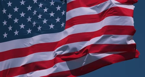 American Flag Waving Against Blue Sky Background
