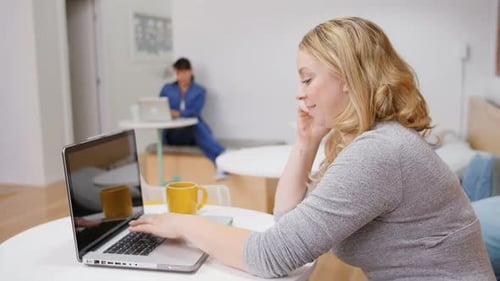 Woman Uses Laptop and Cellphone at Open Office