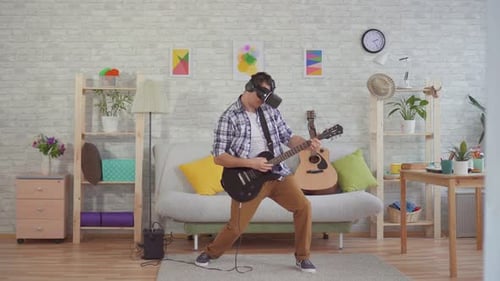 Man Plays Guitar with VR Headset in Living Room