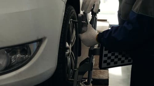 Professioneller Mechaniker, der die Achsvermessung des Autos einstellt