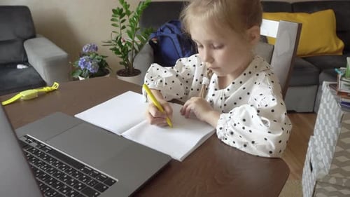 Young Girl Drawing in Notebook at Home