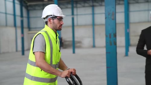 Factory Workers Deliver Boxes Package on a Pushing Trolley in the Warehouse
