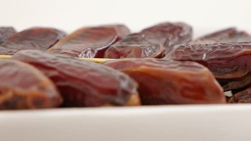 Packed palm dates dried fruit on white surface panning 4K 2160p 30fps UltraHD footage - Phoenix d