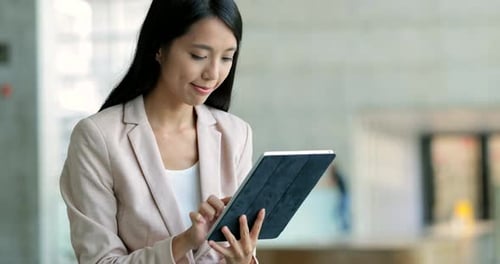Woman Uses Tablet in Modern Office Setting