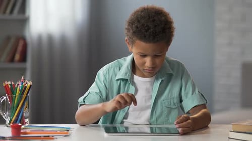 African American Schoolboy Watching His Favorite Educational Show on Tablet
