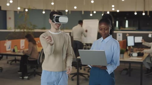 Kaukasischer Geschäftsmann testet ein VR-Simulator-Headset und gestikuliert in der Luft, während seine Frau