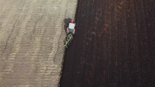 Aerial footage over tractor ploughing field
