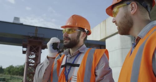 Construction Engineers Discuss Project Using Walkie Talkie