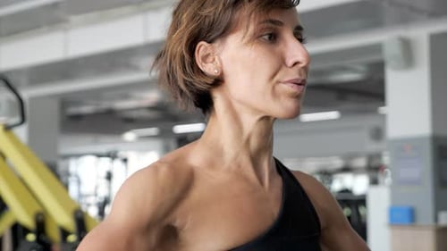Focused Woman Lifting Weights in Gym