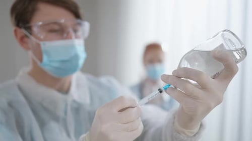 Medical Professional Draws Liquid into Syringe