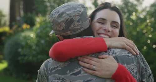 Woman Embraces Military Person in Outdoor Setting