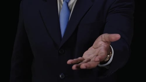 Businessman Hand Offering Gesture Against Black Background