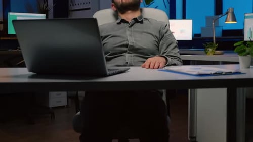 Empresário viciado em trabalho dormindo na cadeira no escritório da empresa de negócios tarde da noite