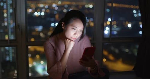 Woman Using Smartphone in City at Night