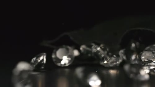 Diamonds Falling onto a Dark Reflective Surface