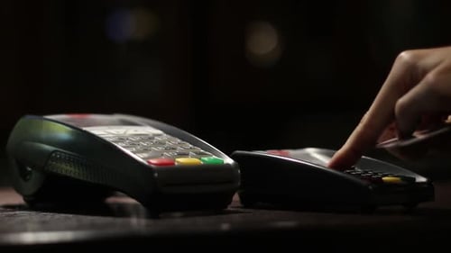 Woman Pays Using A Credit Card Using The Terminal In The Evening