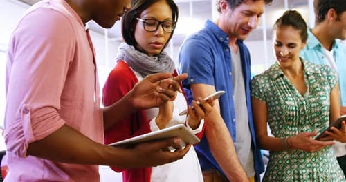Diverse Team Collaborating with Tablets and Smartphones