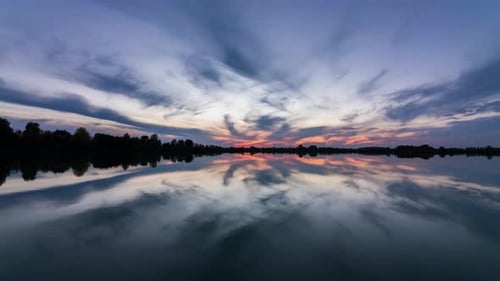 Timelapse of a Beautiful Sunset on the Lake. Reflection of Clouds in Water.