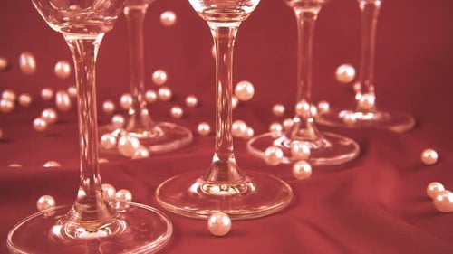 Elegant Wine Glasses with Pearls on Red Surface