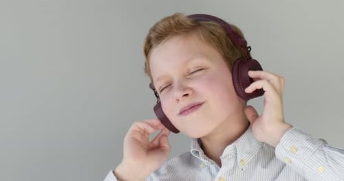 Close-up Portrait. The Boy Is Listening To the Music with Headphones and Dancing .