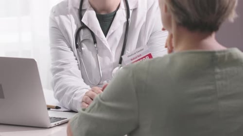 Doctor Holding Female Patient Hands Talking About Treatment Disease in Office