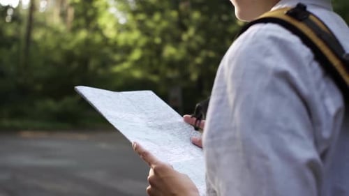 Lost Hiker Looks at Map on Road