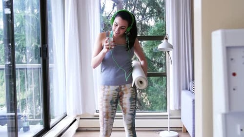 Woman with Headphones and Yoga Mat Dancing