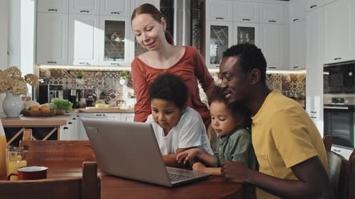 Happy Family Looking at Laptop in Modern Home