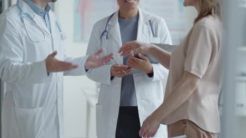 Healthcare Providers Consult With Patient in Clinical Setting