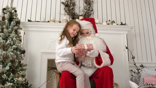 Girl Receiving Gift From Santa Claus at Christmas