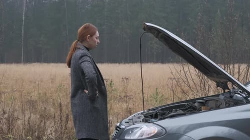 Woman Looks at Car Engine in Rural Area