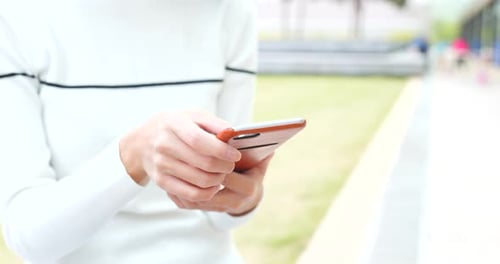 Woman Using Smartphone Device Outdoors in Daylight