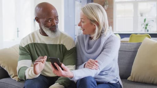Mature Couple Enjoying Mobile Phone Together at Home