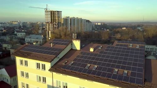 Aerial view of many solar panels mounted of industrial building roof.