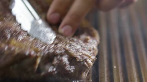 Taking Steak from Grill