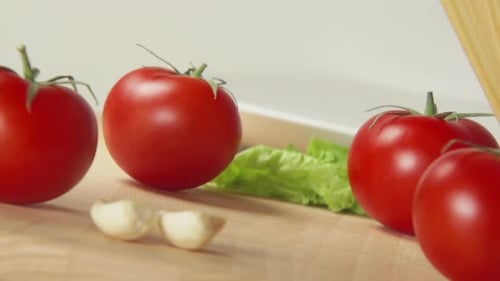 Spaghetti Fall On A Table Between A Ripe Tomatoes And Garlic